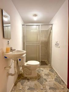 a bathroom with a toilet and a sink and a shower at Villa bella Claudia in Armenia