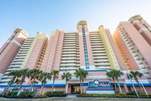 a large pink building with palm trees in front of it at Direct Oceanfront Unit Amazing Views with Pools in Myrtle Beach