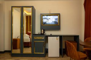 a room with a refrigerator and a table with a mirror at crown taksim hotel in Istanbul