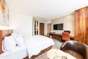 a hotel room with a bed and a desk at First Hotel in Guri