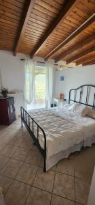 a large bed in a bedroom with a wooden ceiling at Horizon studio apartment in Palaiokatoúna +66 photos