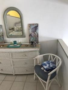a room with a dresser and a chair and a mirror at Tropical Oasis in Christiansted