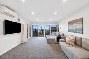 a living room with a couch and a flat screen tv at Scelta in Lorne