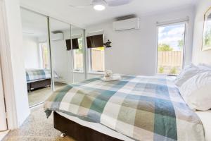 a bedroom with a large bed with a checkerboard blanket at Relax at 42 Cape View Resort in Broadwater +18 photos