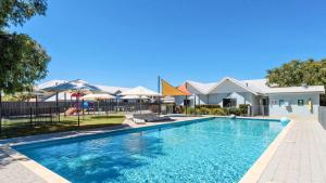 a swimming pool at a resort with umbrellas at Relax at 42 Cape View Resort in Broadwater