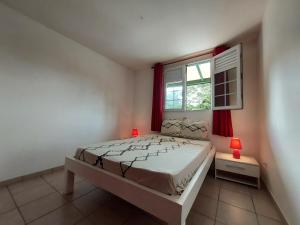 a bedroom with a bed and a window at La créola BAYALOCATION in Rivière-Pilote +21 photos