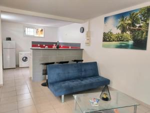 a living room with a blue couch and a table at La créola BAYALOCATION in Rivière-Pilote