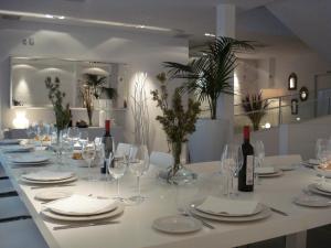 ein Tisch mit Gläsern, Tellern und Weinflaschen in der Unterkunft Hotel Raimblanc in Villargordo del Cabriel