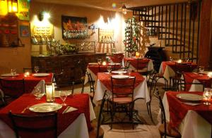 un restaurante con mesas y sillas rojas y un árbol de Navidad en Pousada Casa das Flores, en São Jorge