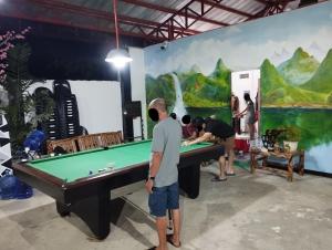 a group of people standing around a pool table at Cuna Del Alri in Samal