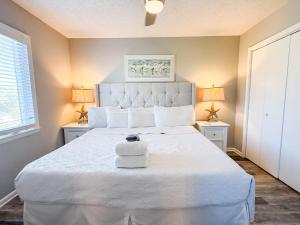 a bedroom with a large white bed with two lamps at North Cape- Behing Trading Post - Pet Friendly in Cape San Blas