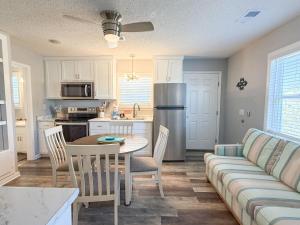 a kitchen and living room with a couch and a table at North Cape- Behing Trading Post - Pet Friendly in Cape San Blas +21 photos