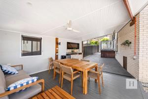 a dining room with a table and a couch at La Dolce Vita - Your next coastal getaway in Caves Beach +17 photos