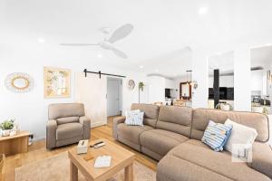 a living room with a couch and a chair at La Dolce Vita - Your next coastal getaway in Caves Beach