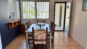 a dining room with a wooden table and chairs at Fantastic Views From Top Floor in Bongaree
