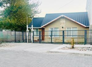 a house with a fence in front of it at Casa Arroyo - Esquel in Esquel +7 photos