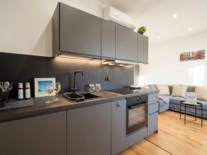 a kitchen with stainless steel appliances and a living room at Sparano Mood 170 in Bari