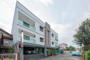 a building with a car parked in a parking lot at RedDoorz Plus at Buah Batu in Bandung