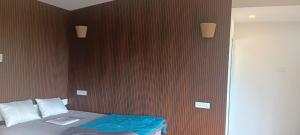 a bedroom with a bed with a brown wall at The Brookshore in Kodaikānāl