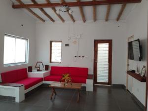 a living room with red couches and a table at Casa los Pinos in Zorritos
