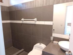 a bathroom with a toilet and a sink at Casa los Pinos in Zorritos +4 photos