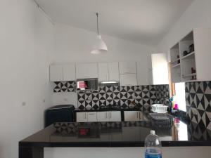 a kitchen with black and white tiles on the wall at Casa los Pinos in Zorritos