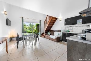 a kitchen and living room with a table and chairs at Kaz Ocean in Saint-Leu