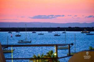 a group of boats in the water at sunset at Beachside Bliss Suite 1 Block from Malecon in La Paz