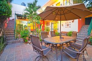 a patio with a table and chairs and an umbrella at Beachside Bliss Suite 1 Block from Malecon in La Paz