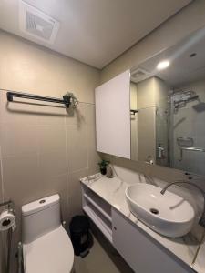 a bathroom with a sink and a toilet and a mirror at LuxeRN Suite at S Residences in Manila +7 photos