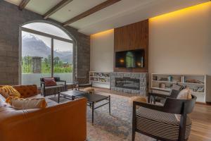 a living room with a couch and a fireplace at Nivasana Manali - A Luxury Boutique Hotel in Manāli