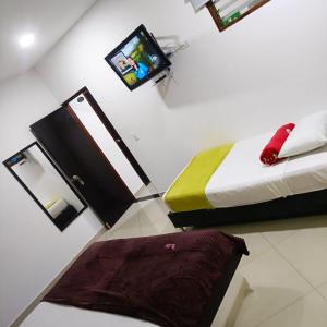 a bedroom with a bed and a tv on the wall at Hotel Laureles Park in Medellín