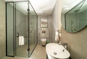 a bathroom with a shower and a toilet and a sink at Nivasana Manali - A Luxury Boutique Hotel in Manāli +48 photos