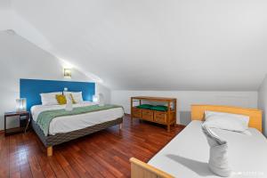 two beds in a room with wooden floors at Kaz Ocean in Saint-Leu +31 photos