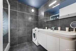 a bathroom with a washing machine and a sink at Kaz Ocean in Saint-Leu