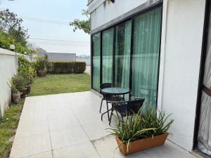 a patio with a table and chairs in a yard at Serene Resort Pattaya in Nong Prue