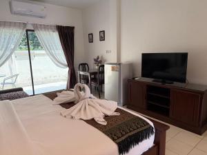 a bedroom with a bed with a towel on it at Serene Resort Pattaya in Nong Prue