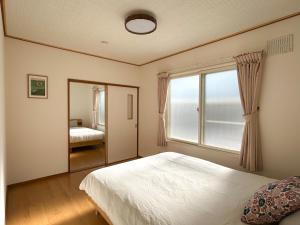 a bedroom with a bed and a large window at Shishimai Kushiro in Kushiro