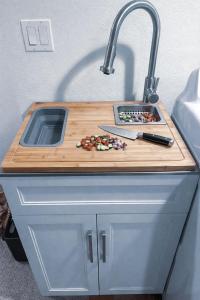 a kitchen counter with a sink and a cutting board at Saffire Villa Rooms in Tacoma +23 photos