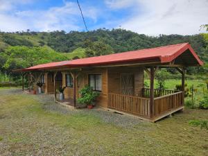a small wooden cabin with a red roof at Cabañas Bambú Pérez Zeledón in San Isidro de El General