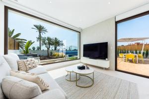 a living room with a large tv and large windows at Edelweiss in Los Alcázares