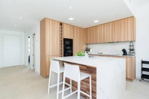 a kitchen with a white counter and wooden cabinets at Edelweiss in Los Alcázares +12 photos
