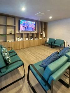a waiting room with couches and a flat screen tv at My Ecolodge in Kutchan