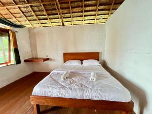 a bedroom with a bed with white sheets and pillows at Angelfish Guest House Raja Ampat in Besir