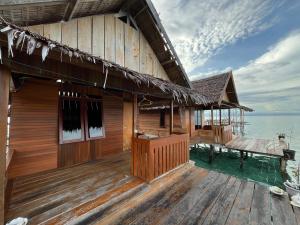 a house on the water with a wooden deck at Angelfish Guest House Raja Ampat in Besir