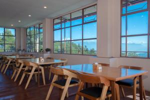 a restaurant with wooden tables and chairs and windows at Hotel Himalayan Vista in Pāti Bhanjyāng