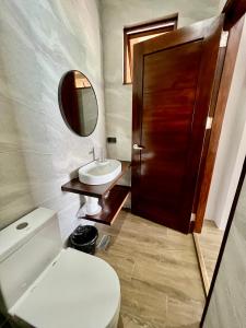 ein Badezimmer mit Toilette, Waschbecken und Spiegel in der Unterkunft Seajour Beach Resort in Ginatilan + 50 Fotos