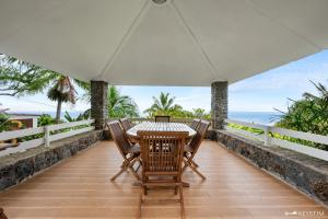 a table and chairs on the balcony of a house at Kaz Ocean in Saint-Leu