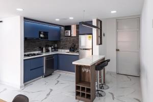 a kitchen with blue cabinets and a refrigerator at Galería 305 in Cartago