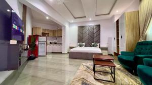 a large living room with a bed and a kitchen at Hillgates Apartments Ikeja in Ikeja